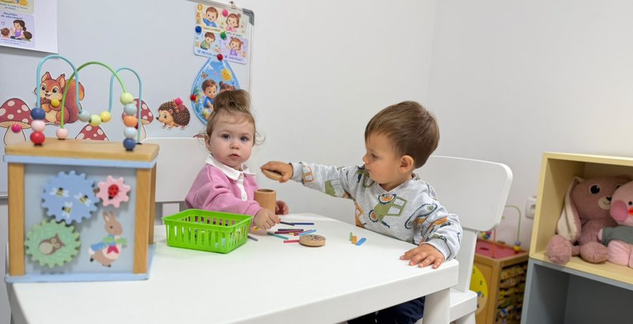 Doi copii care se joacă la masă la creșa „Pui de Academicieni”