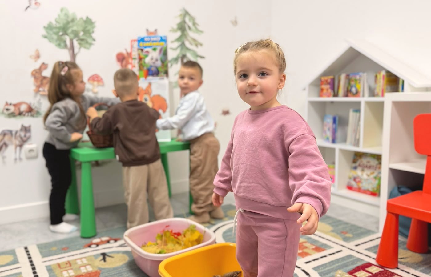 Fetiță zâmbitoare în sala de joacă a Academiei Copiilor