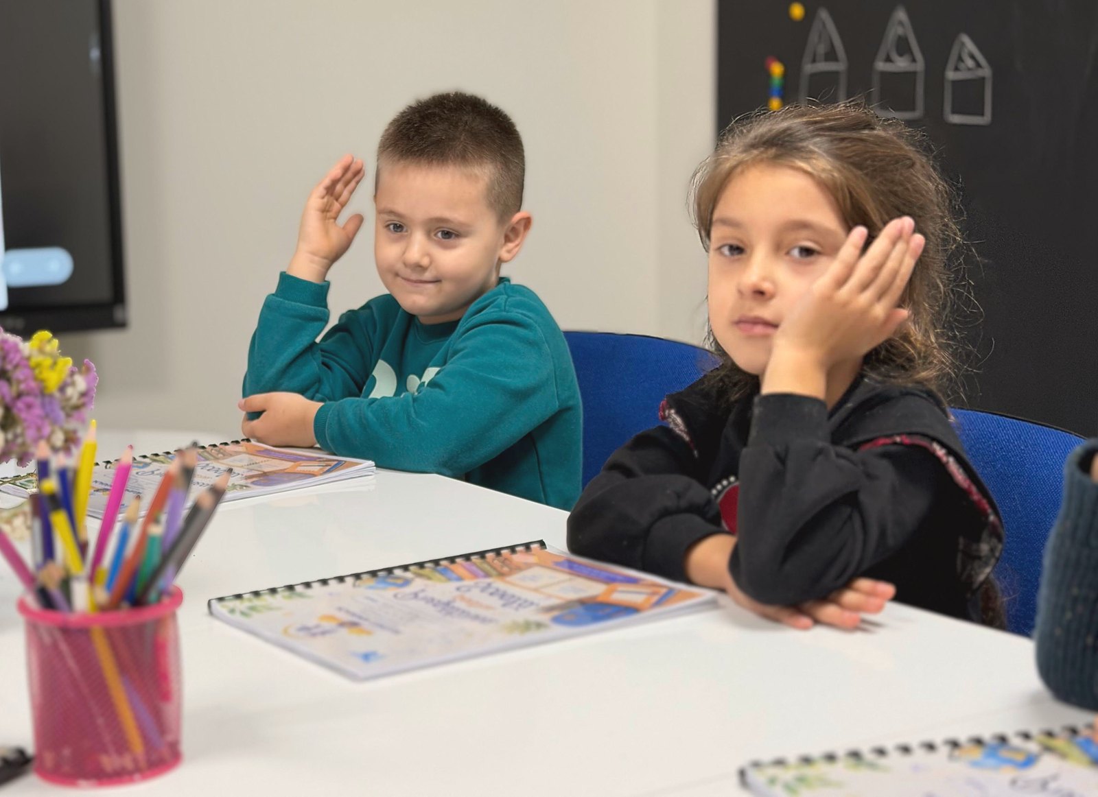 Copii la lecția de pregătire pentru școală, cu caietele Academiei Copiilor